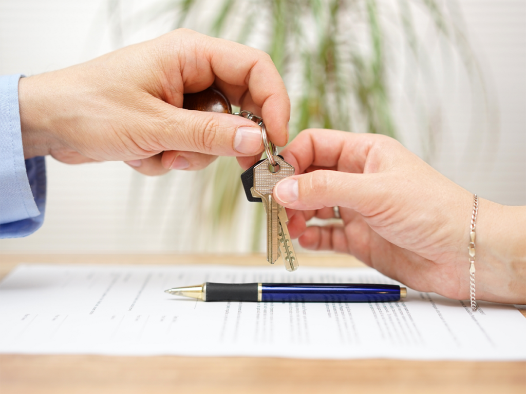 realtor's hand giving keys to a home buyer
